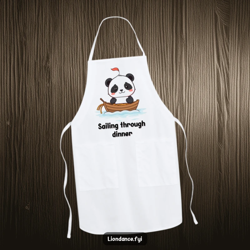 Mischievous panda using a fortune cookie as a sailboat on a noodle ocean, featured on a kitchen apron.